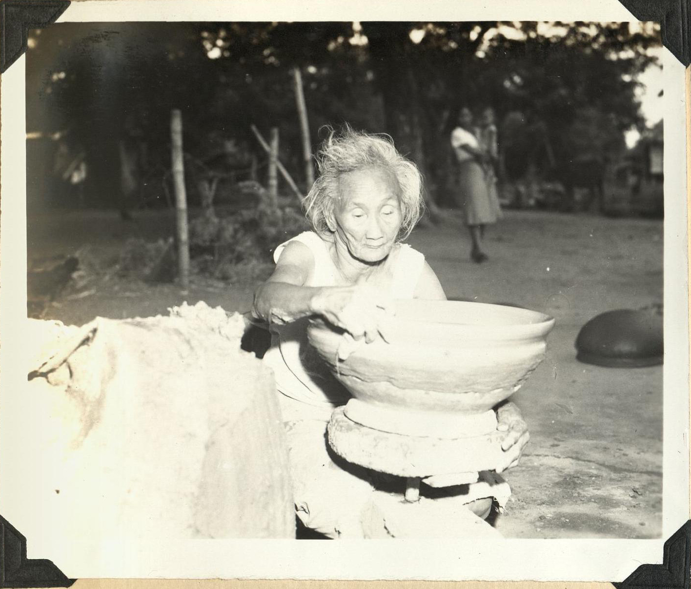 [Untitled – Older woman making pottery].