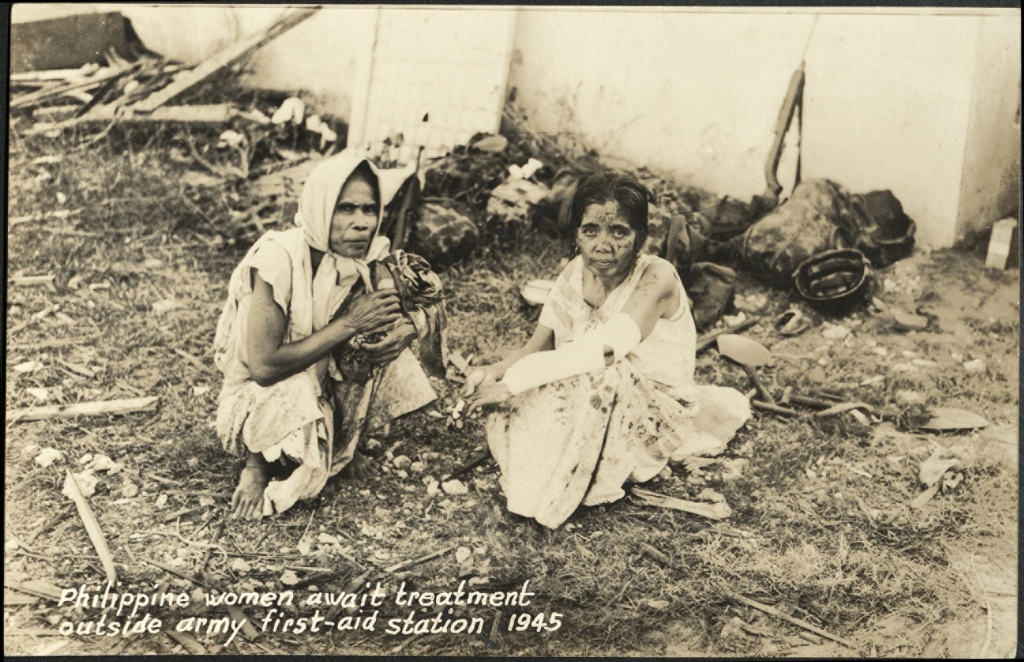Philippine women await treatment outside army first-aid station, 1945.