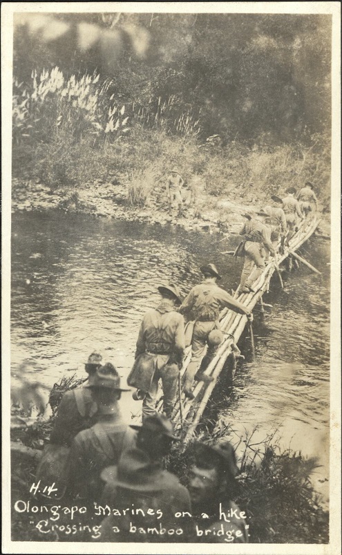 H. 14. Olongapo Marines on a hike. “Crossing a bamboo bridge.”