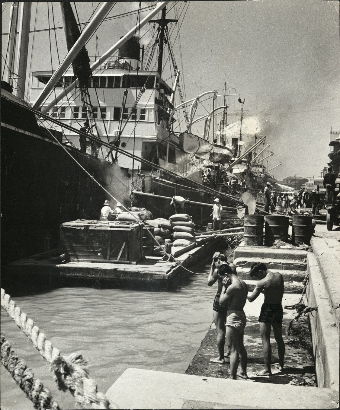 12. Filippino [Filipino] winnows his rice as of old – Part of the Filipinos rice crop is shipped abroad. Here’s a cargo of the white and nutritive kernels being loaded aboard a vessel moored to a pier in Manila’s Pasig River.  Evans 2662.