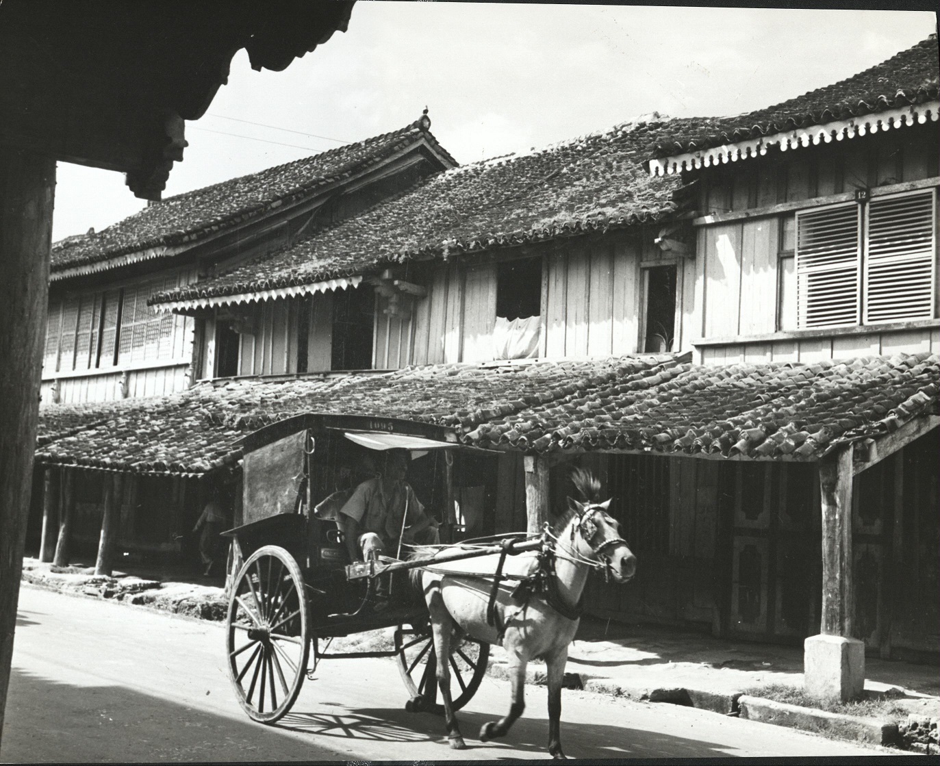 246. PHILIPPINES: Street peddler carrying supplies thru residential section in wagon. 1214.