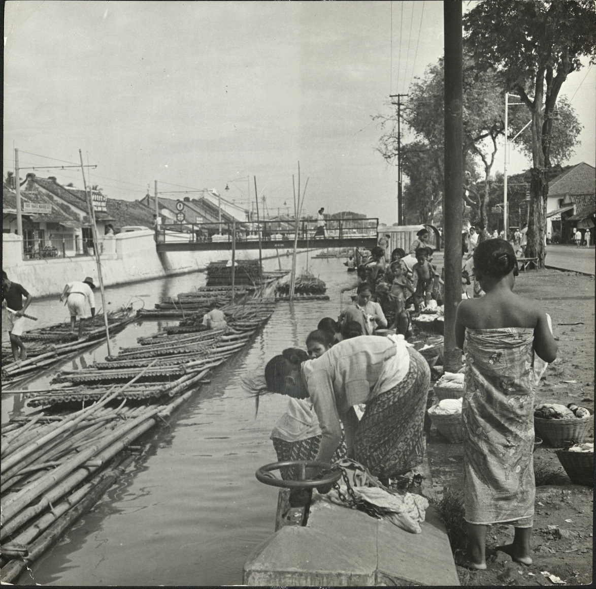 [Untitled – Laundry along a canal with bamboo rafts].