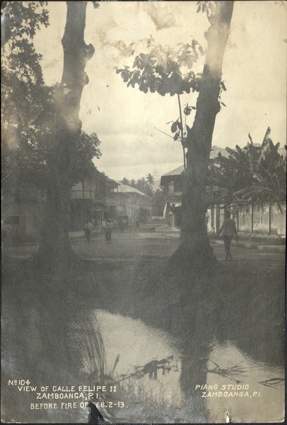 No. 104. View of Calle Felipe II, Zamboanga, P. I., before fire of Feb. 2 – 13 [Artilicias Canal].