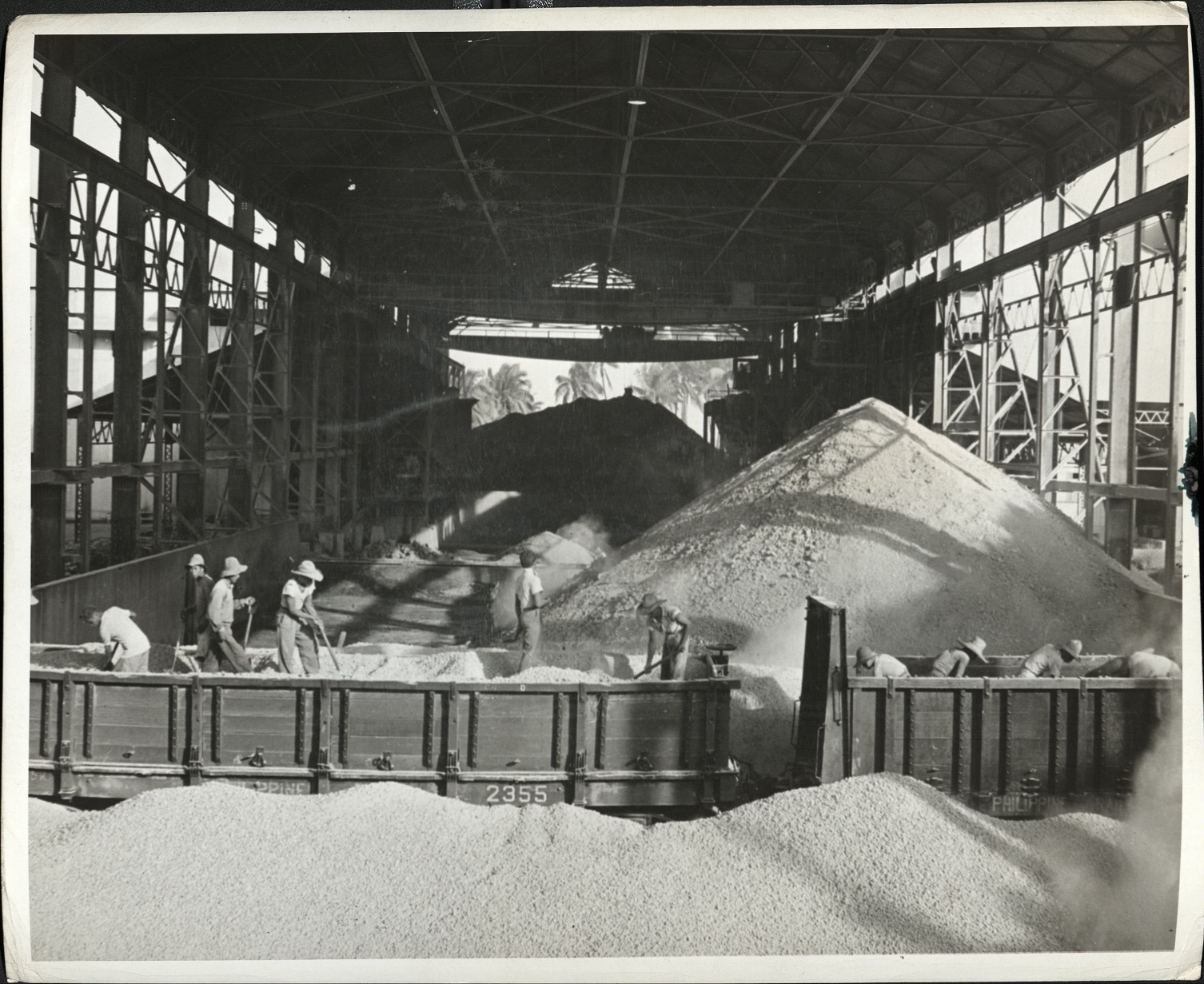 94. PHILIPPINES: Loading fine sand gravel in a storehouse on Luzon. In background are cocoanut [coconut] palms. Jacobs – 1214.