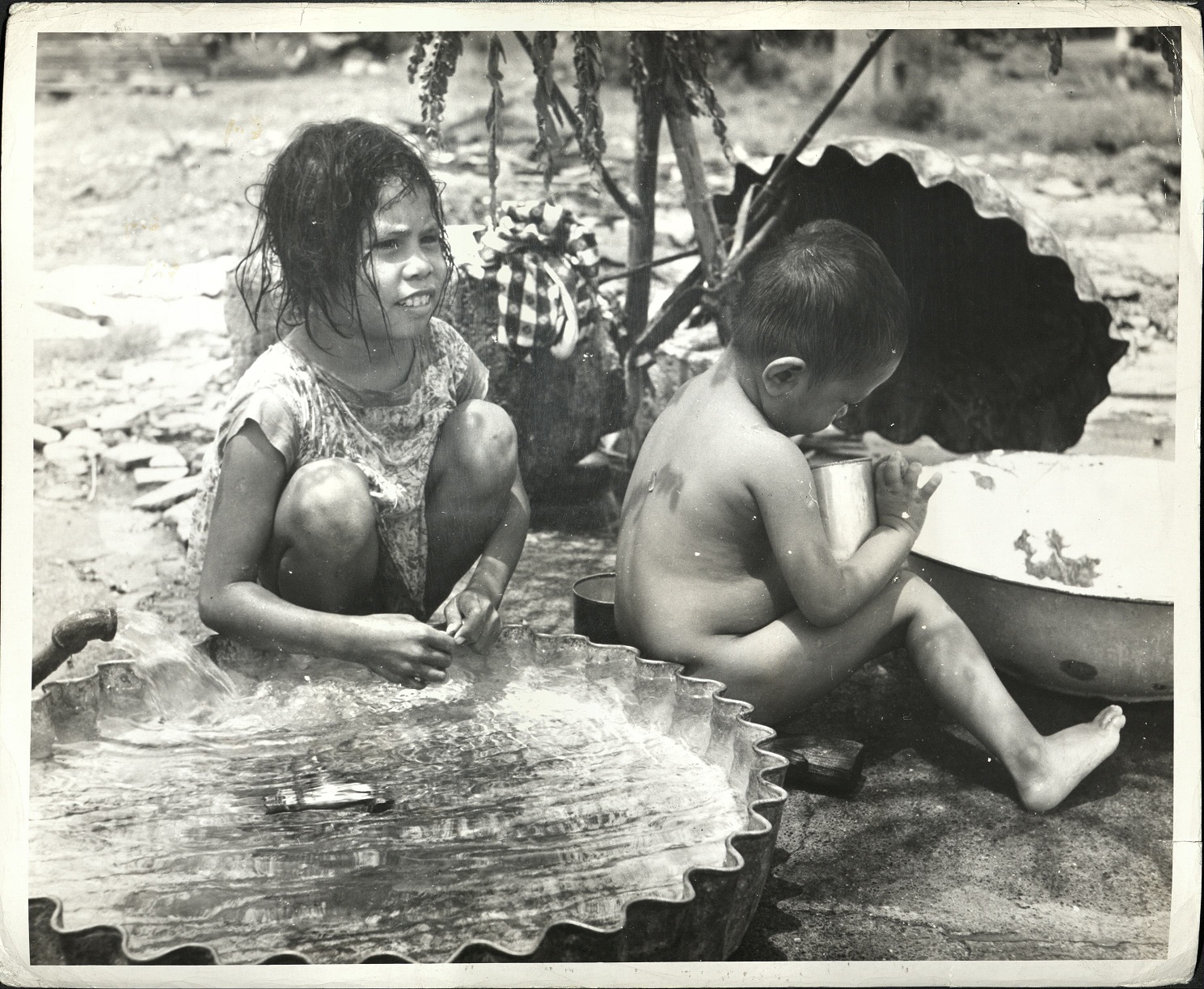 21. PHILIPPINES – Children. Young sister keeps a wathcful eye on her brother near their Manila home.  J-1436.