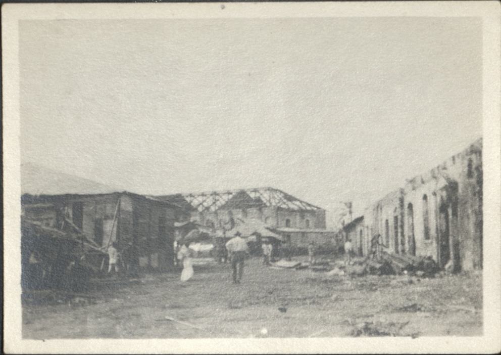 [Illegible – Philippine street. Cleanup after a typhoon, building lost its roof].