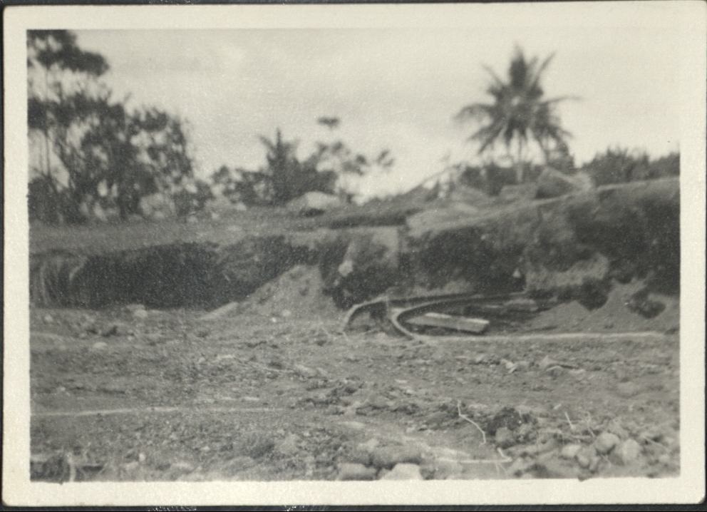 [Untitled – Twisted railroad tracks covered with dirt and rocks after a flood or landslide].