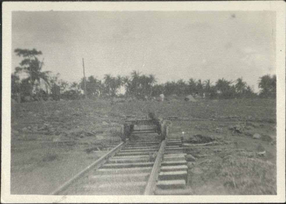 [Untitled – Man inspects railroad tracks covered with dirt and rocks after a flood or landslide].