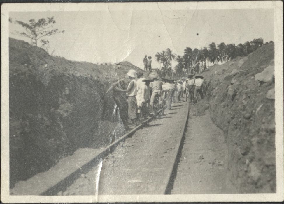 [Untitled – Men excavate railroad tracks covered with dirt and rocks after a flood or landslide].