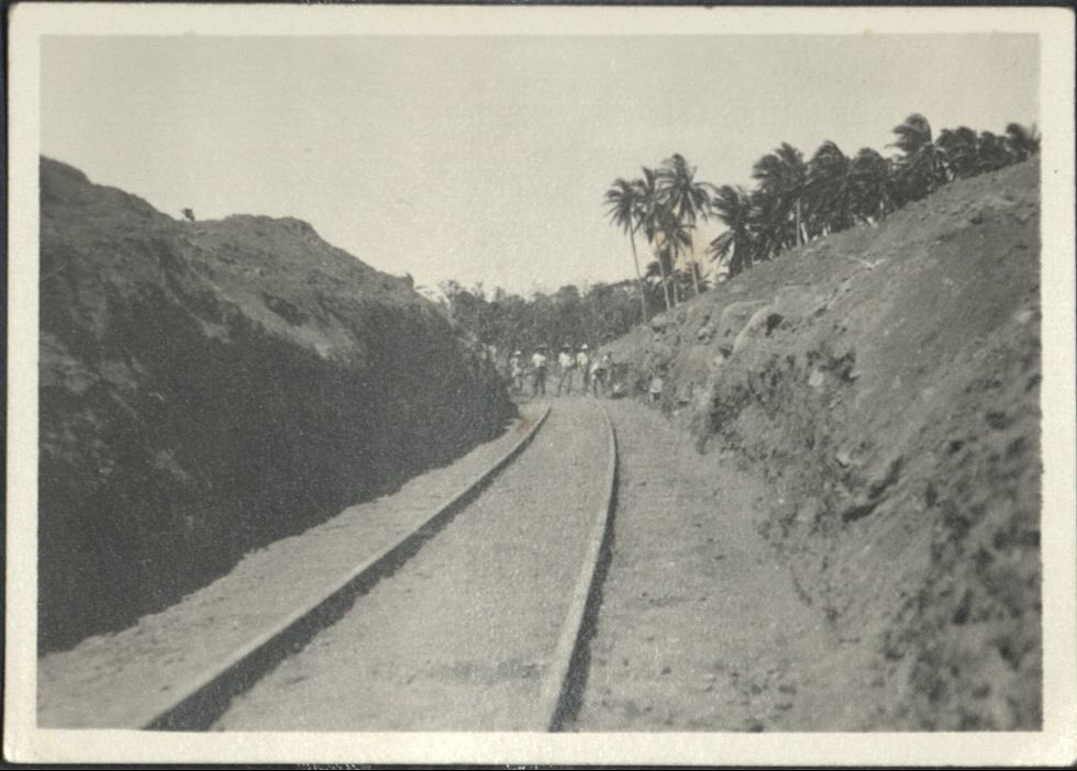 [Untitled – Men excavate railroad tracks covered with dirt and rocks after a flood or landslide].