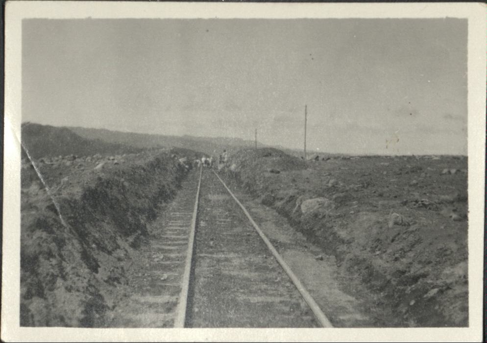 [Untitled – Men excavate railroad tracks covered with dirt and rocks after a flood or landslide].