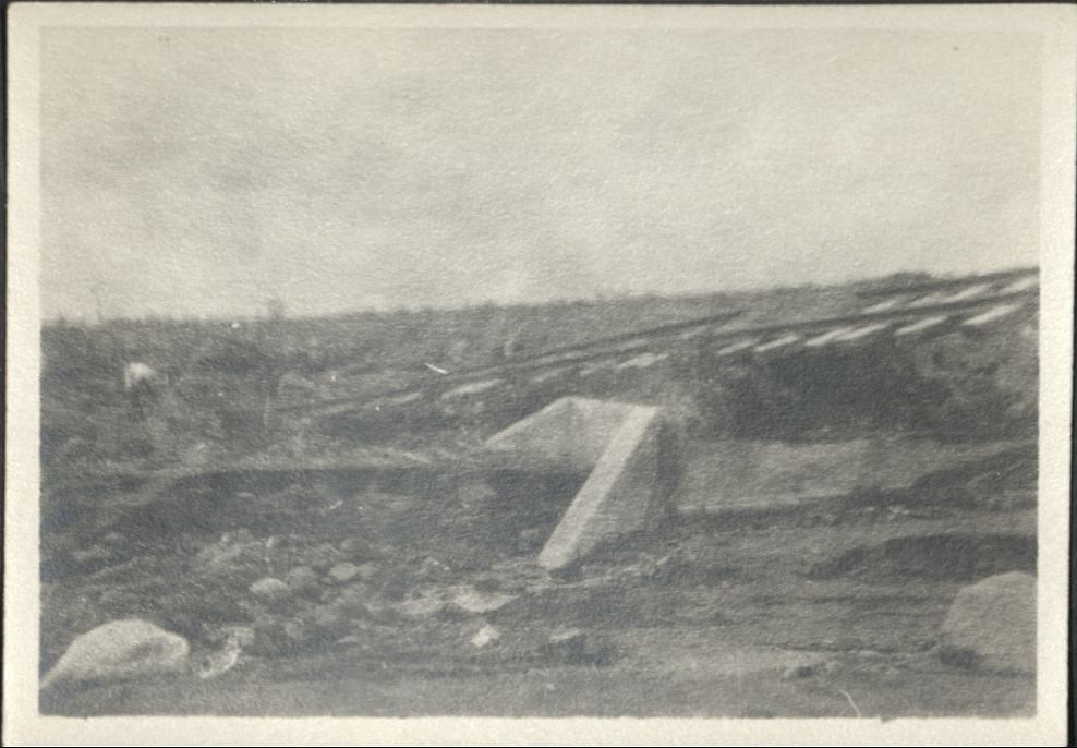 [Untitled – Washed-out bridge and  railroad tracks covered with dirt and rocks after a flood or landslide].