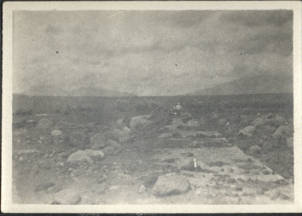 [Untitled – Man in distance inspecting washed-out bridge and  railroad tracks covered with dirt and rocks after a flood or landslide].
