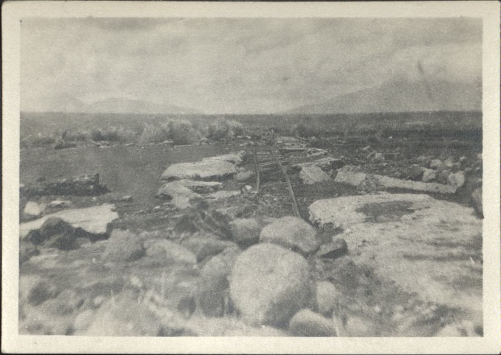 [Untitled – Washed-out railroad tracks lie amid large boulders after a flood or landslide].