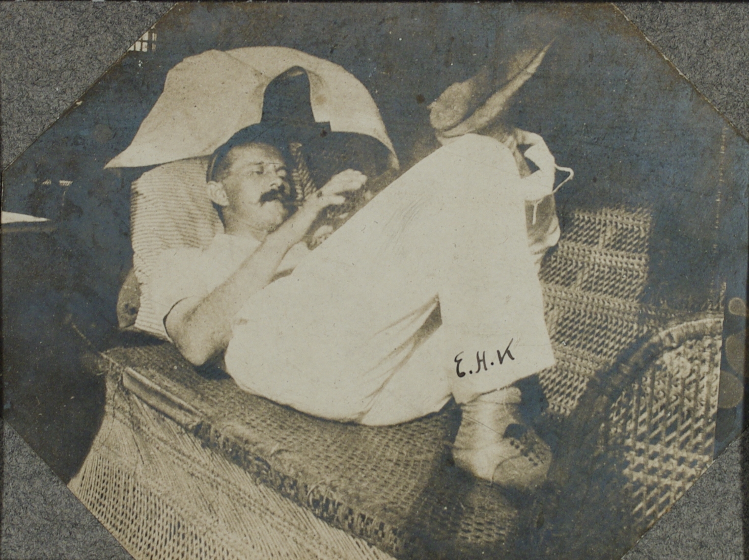 E.H.K. [Soldier relaxing on a wicker settee].