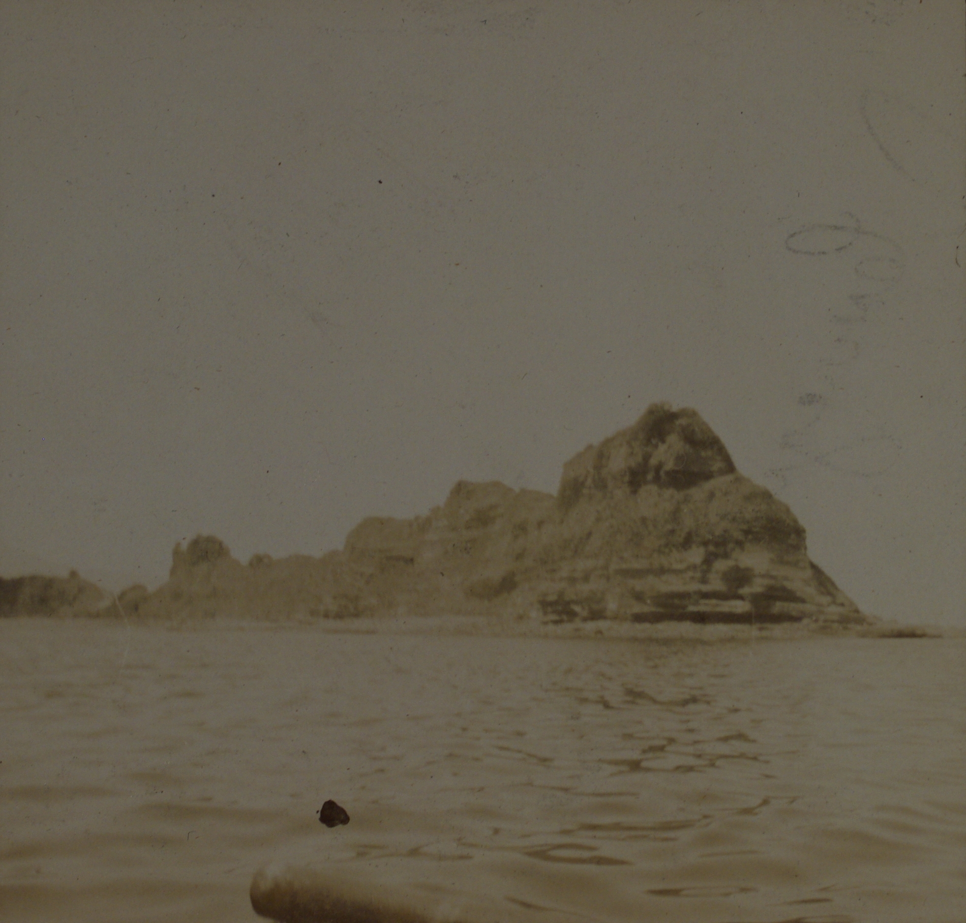 [Untitled – Small rocky island seen from boat].