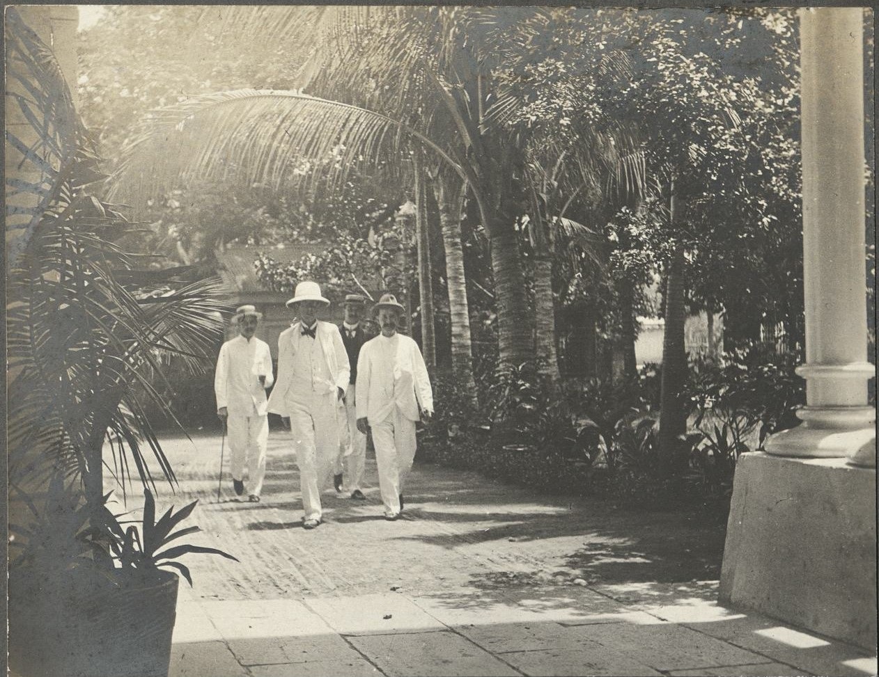 [Untitled – Four expatriate men walk in driveway].