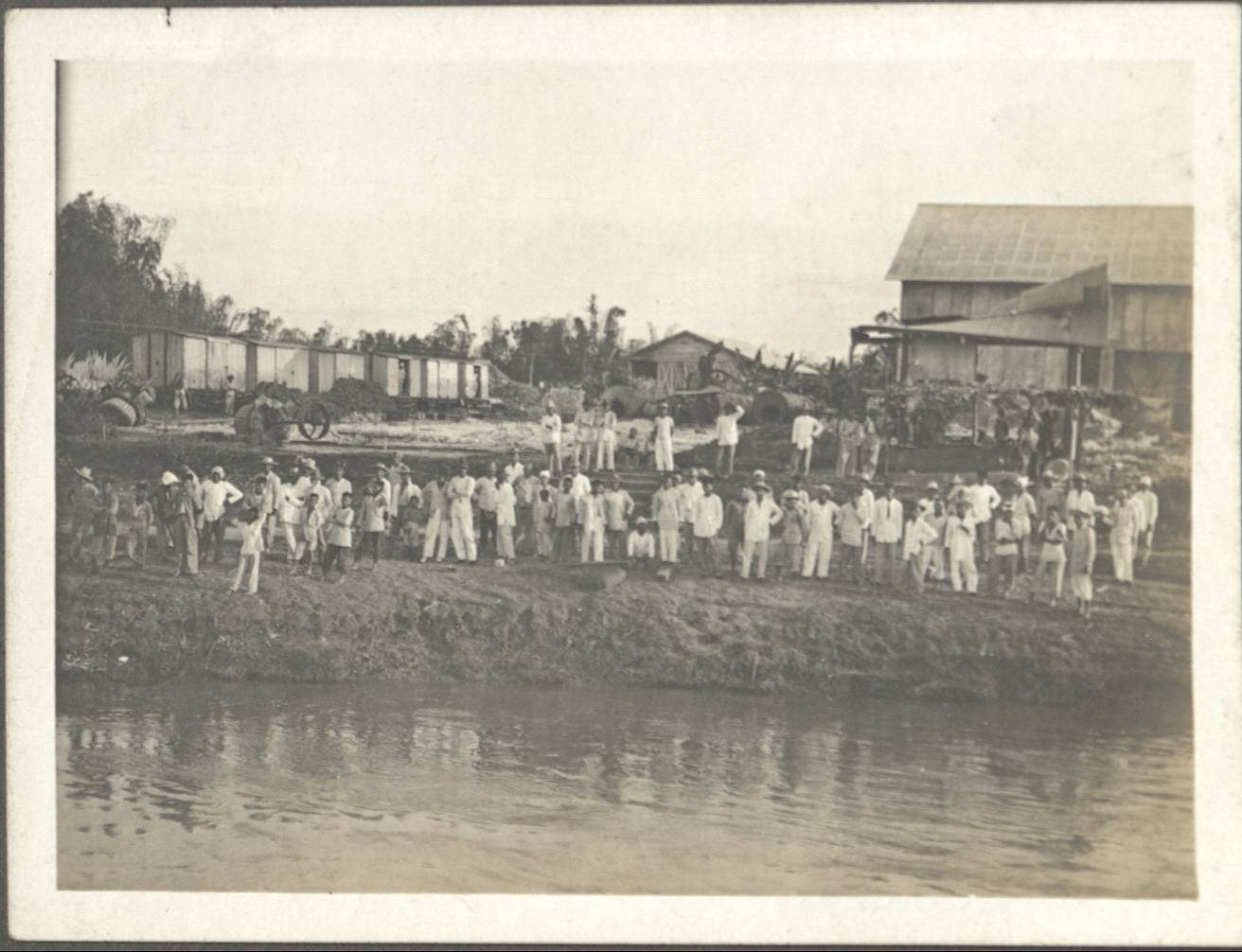 [Untitled – Group of Filipinos gathered on a riverbank in front of an abaca operation?].