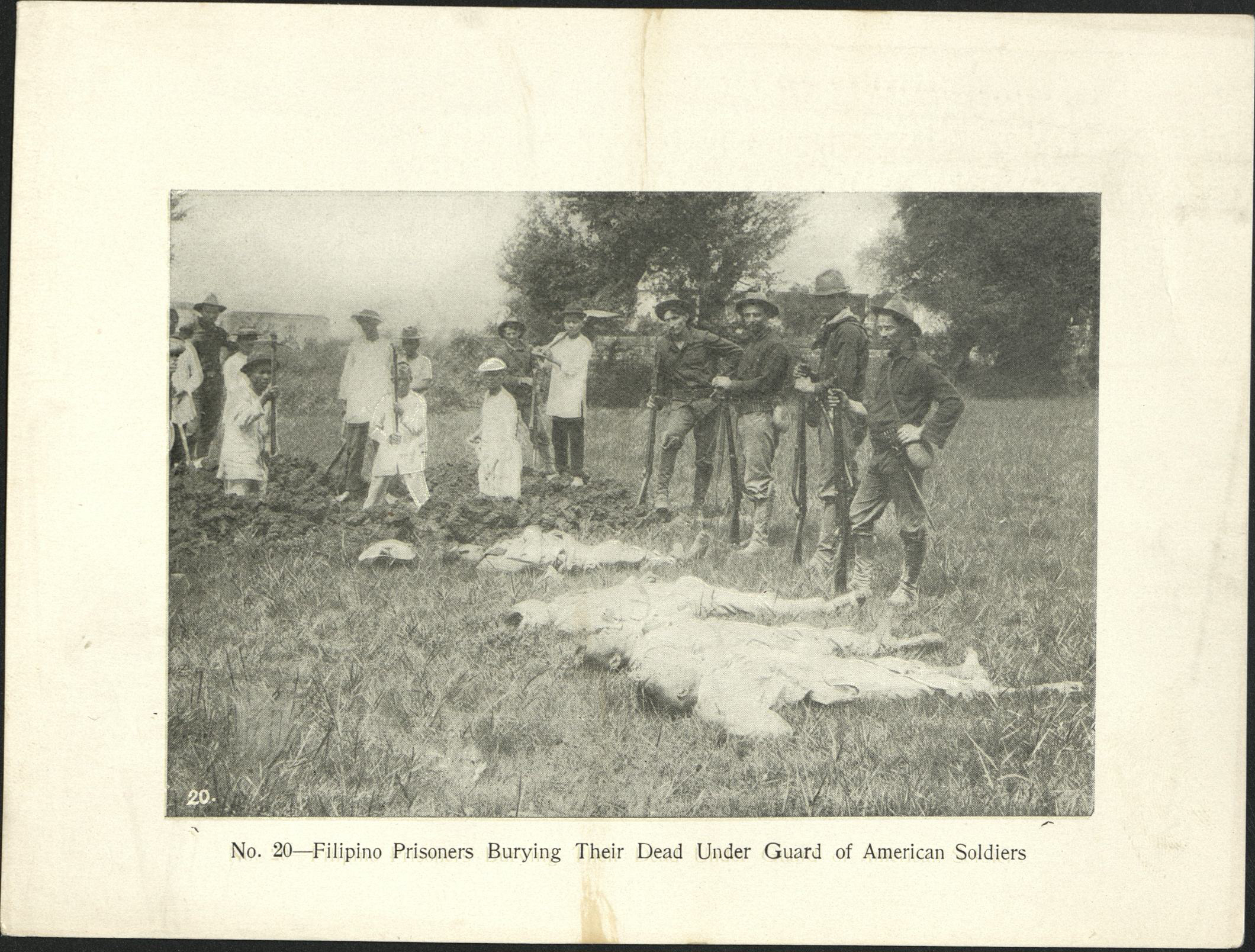 No. 20 – Filipino prisoners burying their dead under guard of American soldiers.
