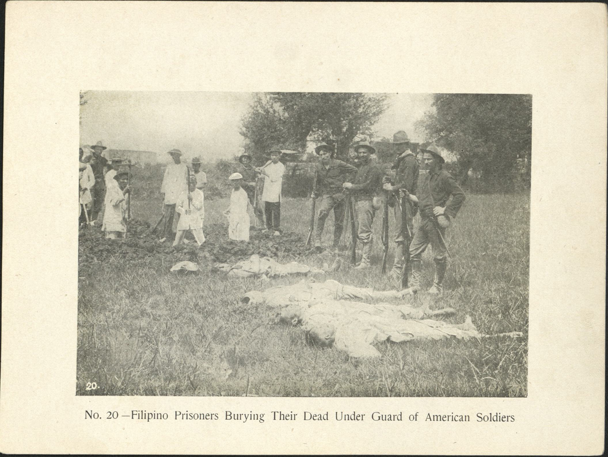 No. 20 – Filipino prisoners burying their dead under guard of American soldiers.