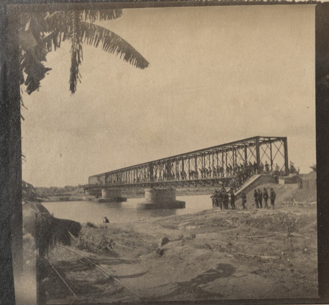 [Untitled – Soldiers stand on railroad bridge over the Pampanga River].