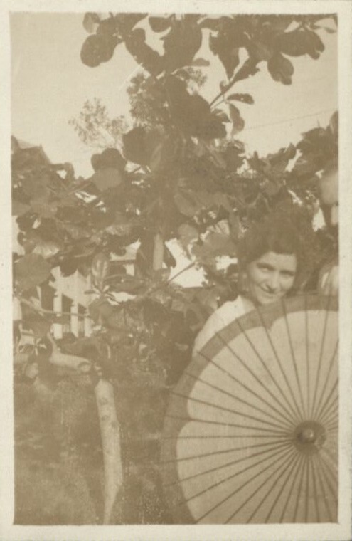 [Untitled – Woman posing outdoors with paper umbrella].
