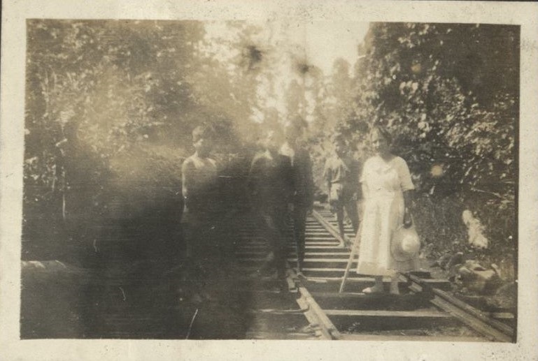 [Untitled – American woman poses with Muslim men on railroad track in Mindanao].