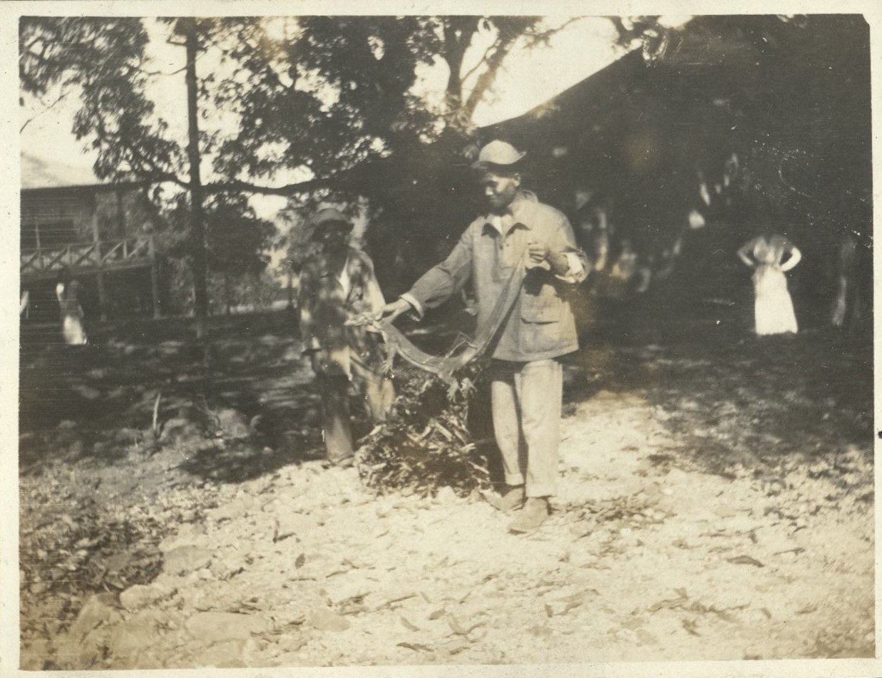 [Untitled – Filipino holds a monitor lizard, Fort Mills].