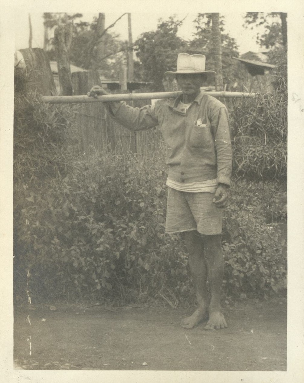 [Untitled – Filipino with shoulder pole carrying zacate?].
