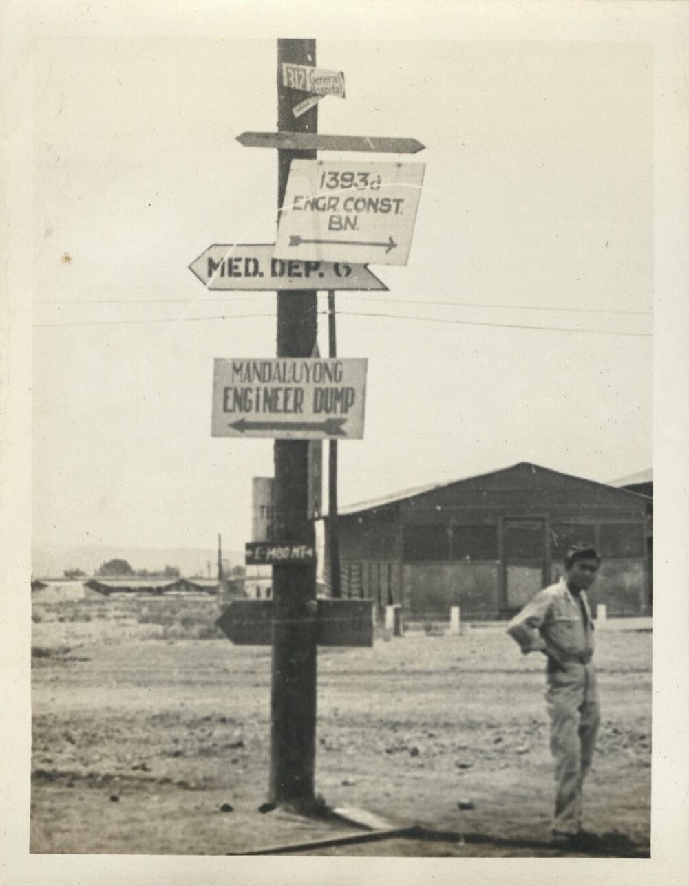 Seen around the 29th [Engineer Base Topographic Battalion. Soldier stands by directional signboards].