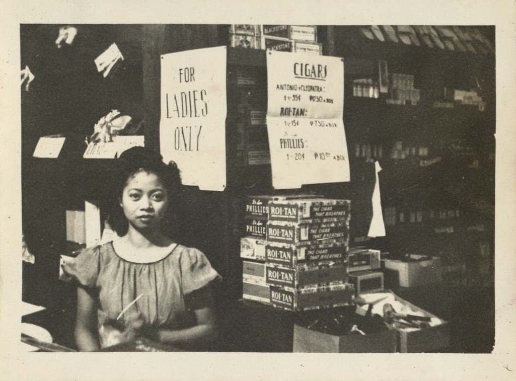 [Untitled – Filipina shopgirl with cigars].