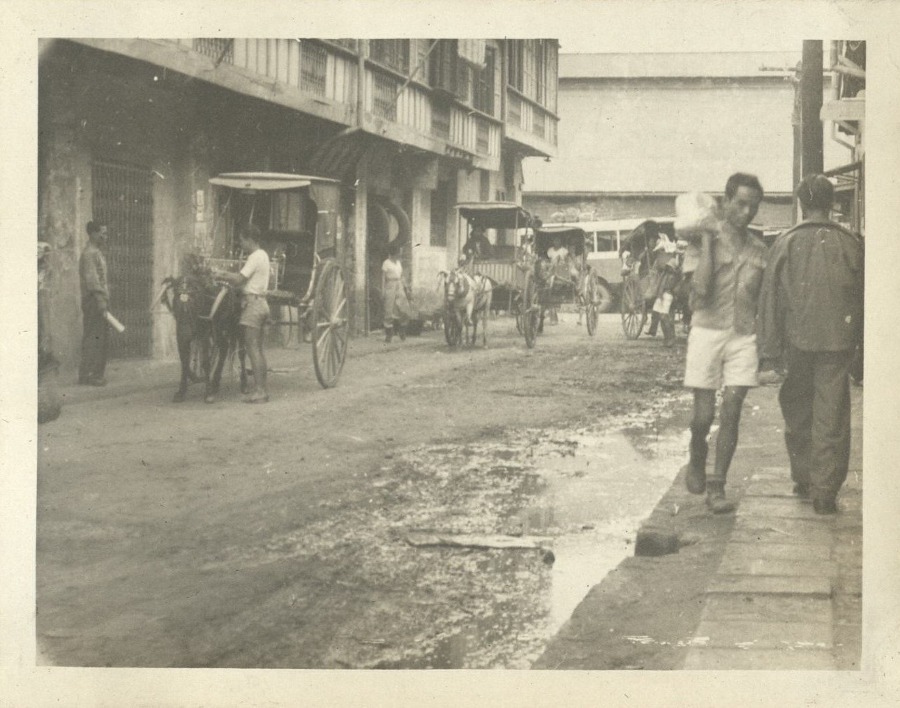 [Untitled – Calesas and pedestrians on a Manila street].