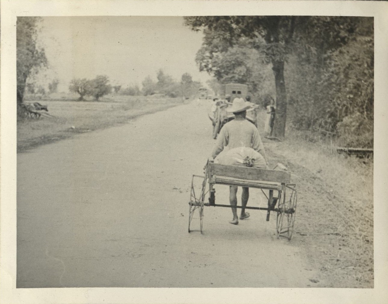 [Untitled – Hand-pulled cart with metal hoop wheels].