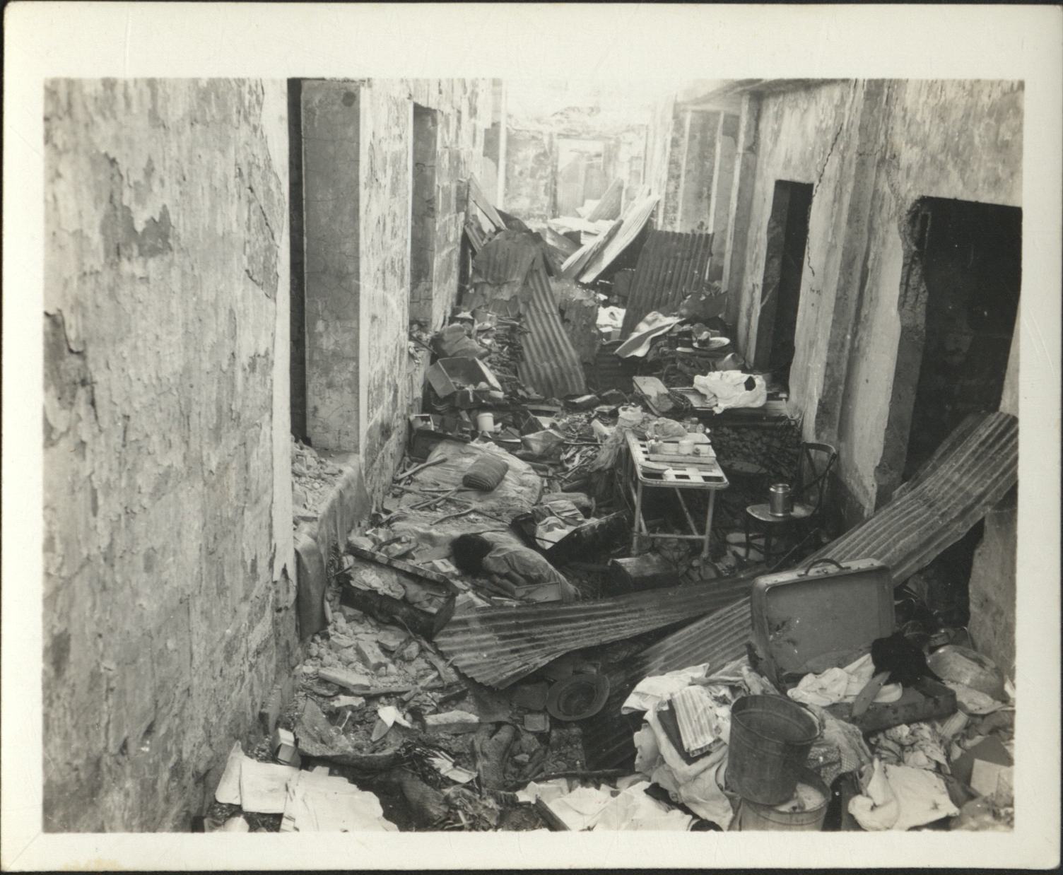 [Untitled – Death and destruction in Manila during liberation: Looted possessions and a body in an alley, February 1945].