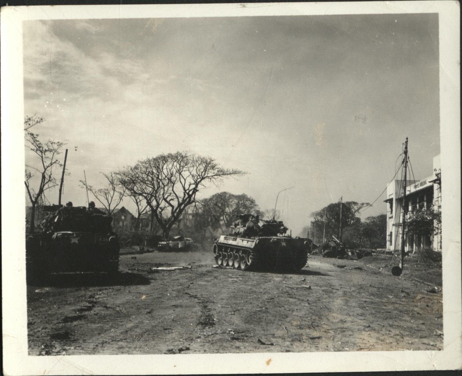 [Untitled – Fighting in Manila during liberation: Armored Personnel carrier advances in Ermita near Finance Building and Central Methodist Church, February 1945].
