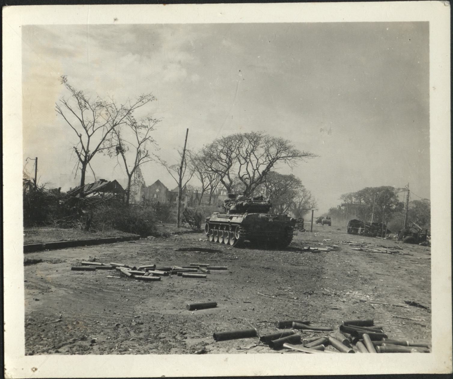 [Untitled – Fighting in Manila during liberation: Armored Personnel carrier advances in Ermita near Finance Building and Central Methodist Church, February 1945].