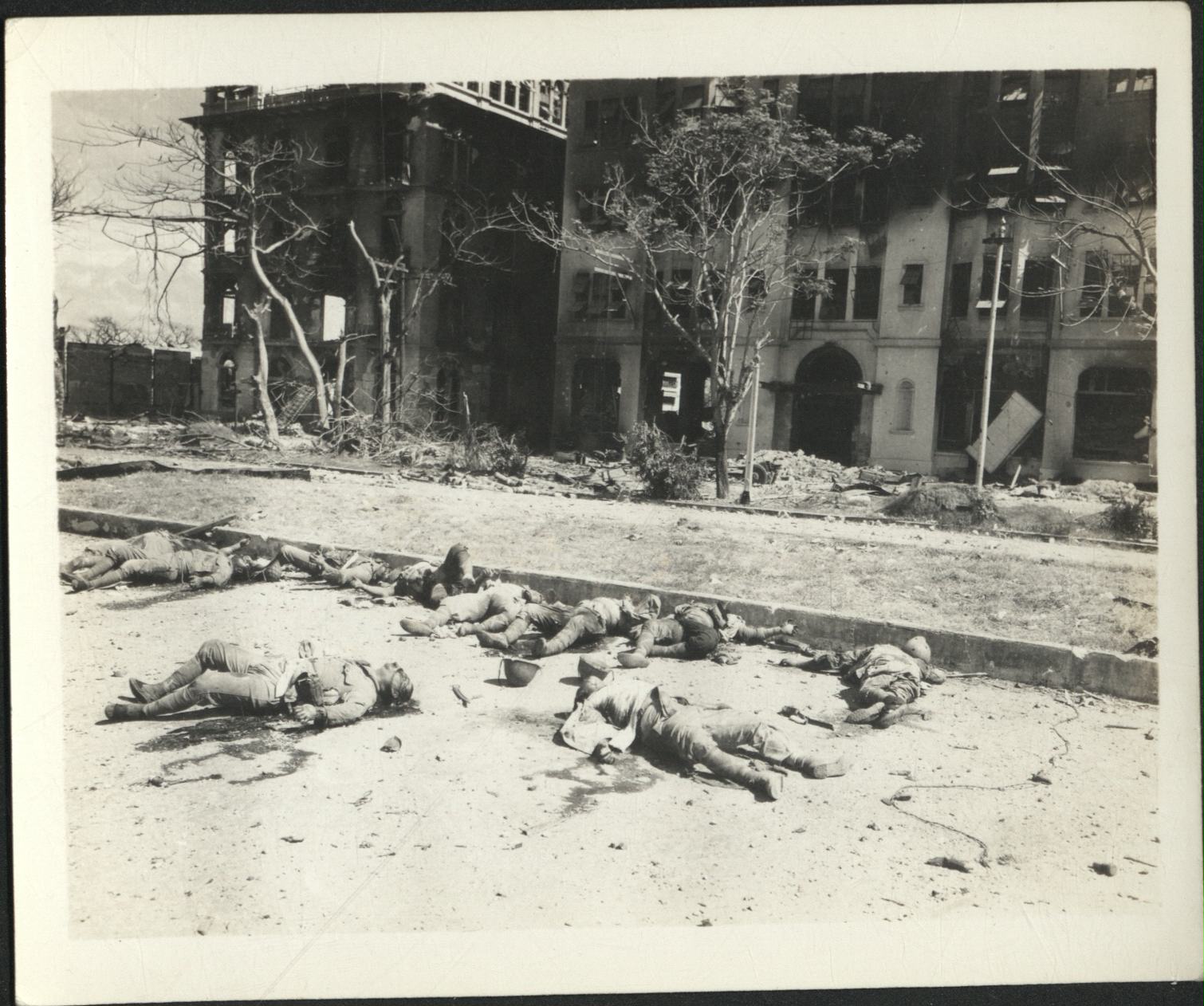 [Untitled – Destruction and dead bodies outside Luneta Hotel and University Park Apartments, Ermita, during liberation, February 1945].