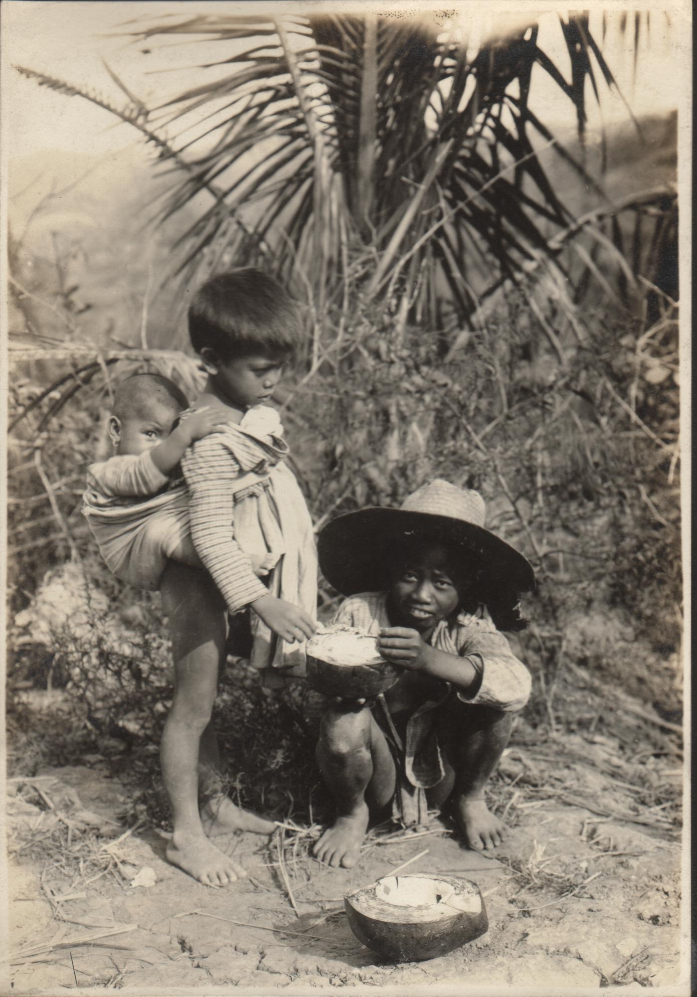 Two young Tingian [Tinguian] children eating coconut meat. San Emilio [Ilocos Sur].