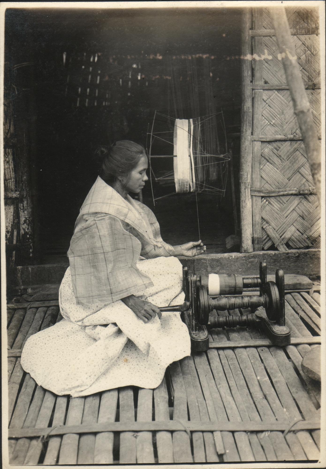 An Ilocano woman spinning thread.