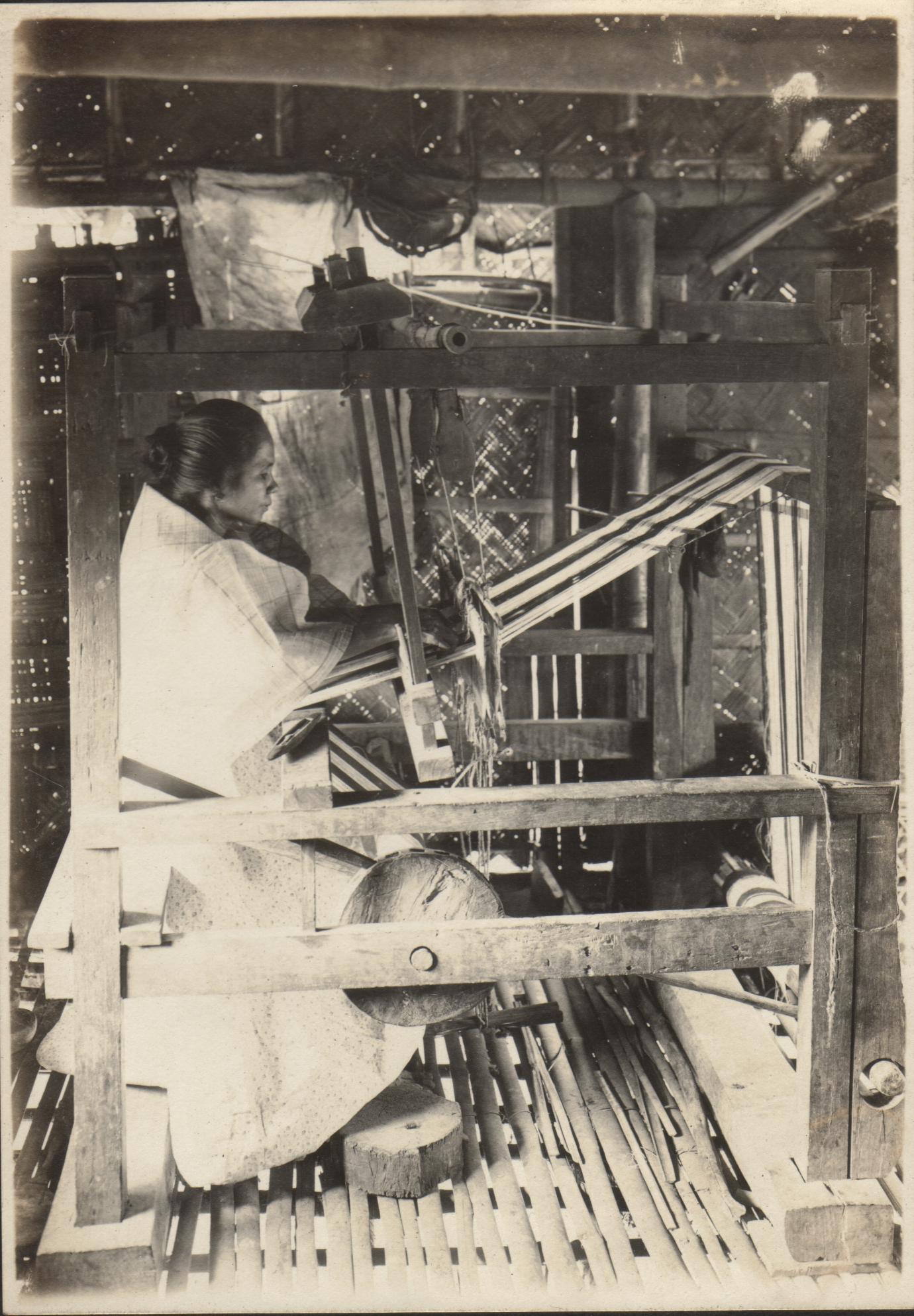 An Ilocano woman weaving in her native loom. Vintar, Ilocos Norte.