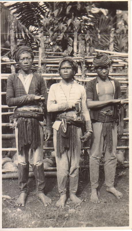 [Untitled – Three indigenous men pose with one hand on their large knives].