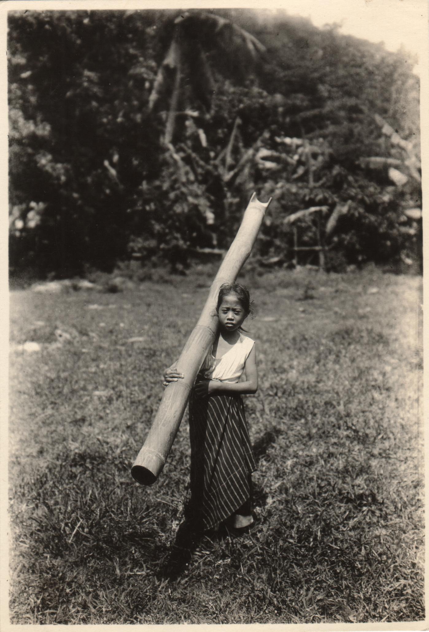 Little Visayan girl carrying water with a bamboo, Jaro, Iloilo.