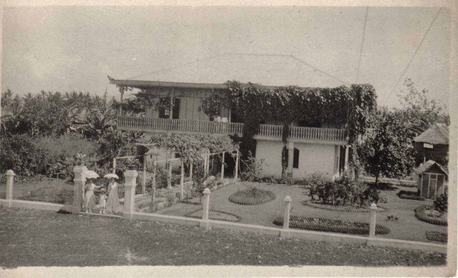 [Untitled – Two women and a girl pose in front of a residence. La Casa Grande, Central San Isidro, Kabankalan, Negros Occidental?].