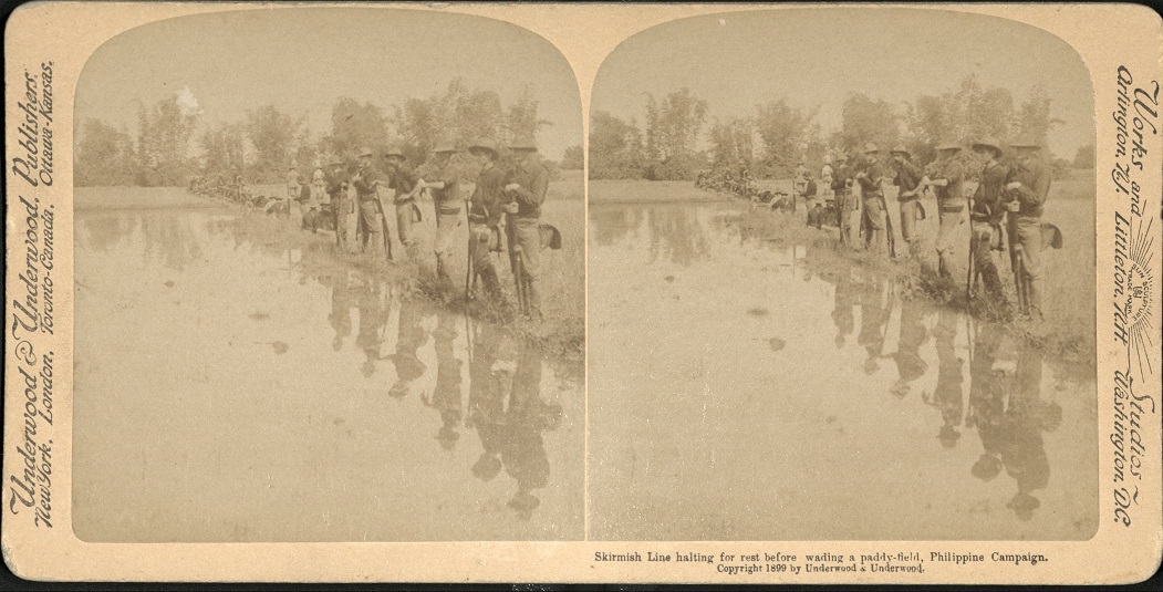 Skirmish Line halting for a rest before wading a paddy-field, Philippine Campaign.